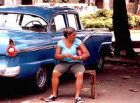 An old woman looks after a car in Havana.